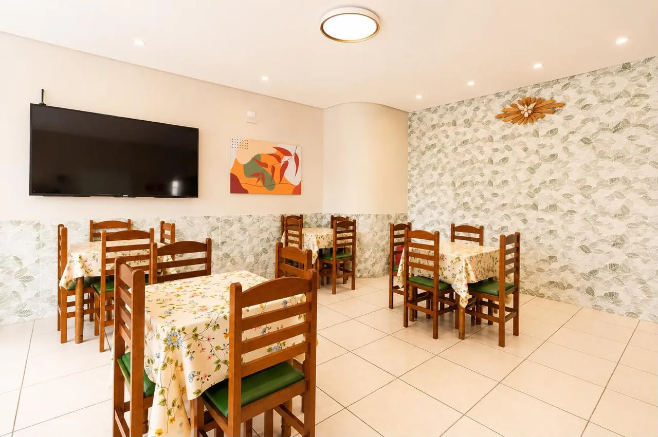 Refeitório da Unidade Juvenal Parada com mesas decoradas e TV